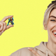 A woman smiling and pointing at a tiny Samus from the Metroid series.
